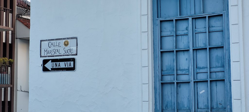 weiße Hauswand mit blauen Fensterladen