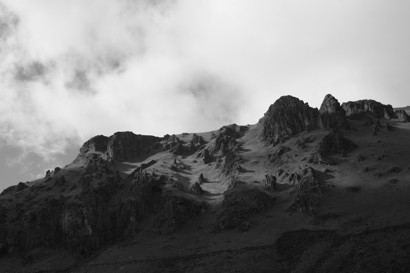 Berg mit grünen Wiesen und Felsen