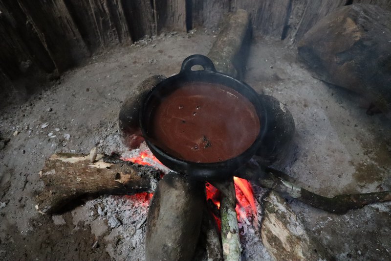 Topf mit fertigem Kakao auf Holzfeuerstelle