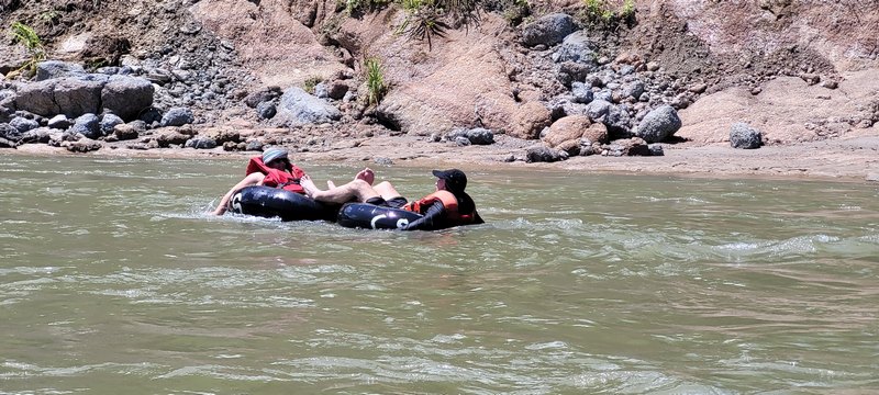 Menschen triben auf Gummireifen auf einem Fluss