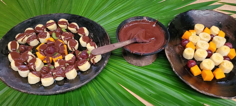 Getöpferte Schalen mit Bananenstücken, Mangostücken überzogen mit Kakaocreme